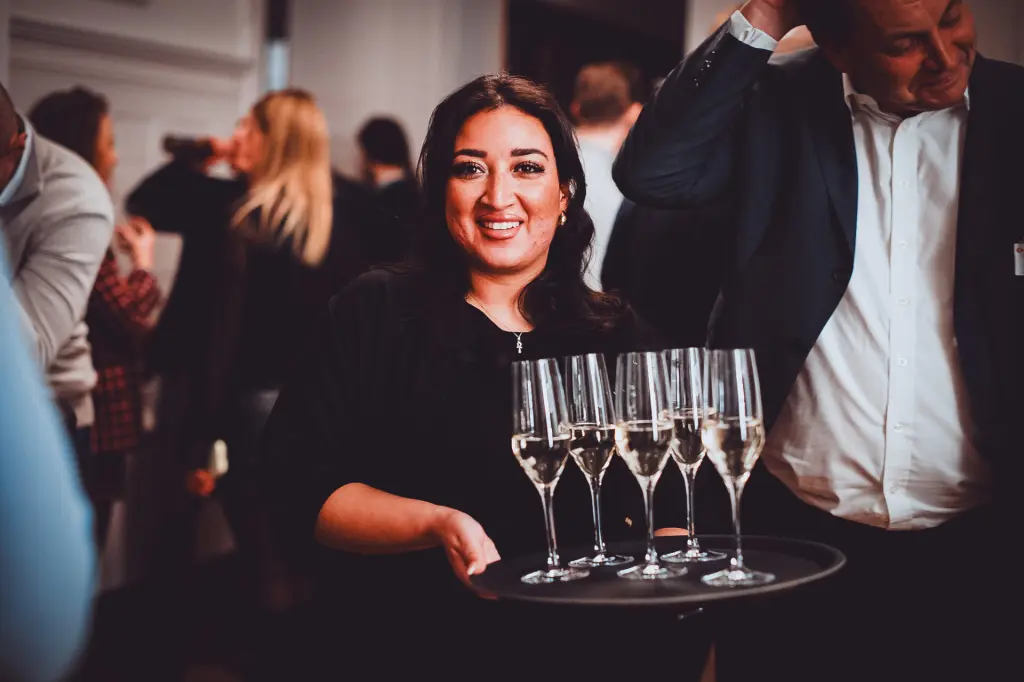 A waitress serves champagne at a business event – an example of professional event photography at corporate events.
